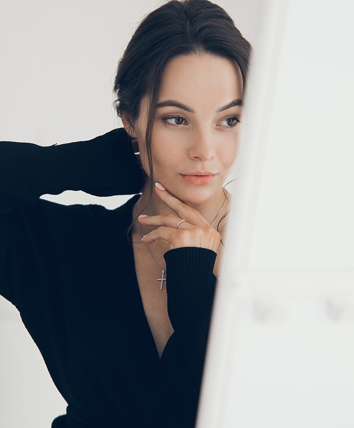 Woman in black sweater with thoughtful expression.