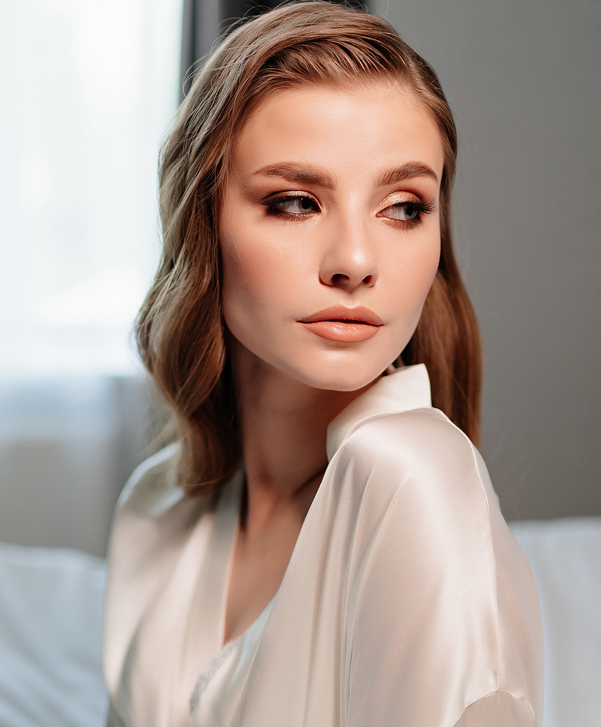 Model in a silk robe with soft makeup.