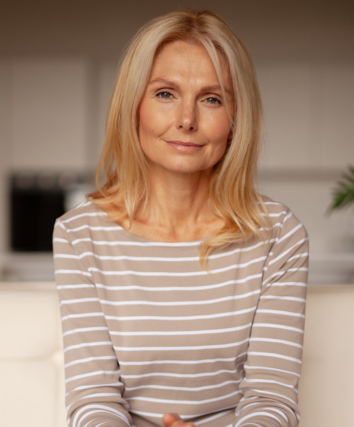 Woman with long hair in striped top, smiling.